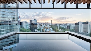 A modern interior with a large window offering a cityscape view. - 1BR Executive Reforma View + Pool + Cowork (Mexico City)