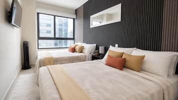 A modern hotel room with two beds, a large window, a flat-screen TV, and a wall-mounted mirror.
