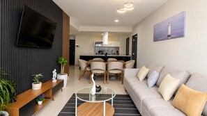A modern living room with a sofa, a coffee table, and a TV mounted on the wall. - 3BR for 12 | Polanco | Pool, Gym | Antara Carso (Mexico City)