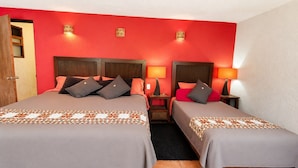 A hotel room with two beds, each with a headboard, bedside tables, lamps, and a door. - Sparrow | King and Breakfast in the Woods (Valle de Bravo)