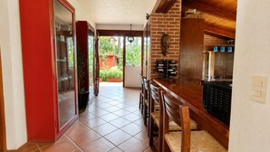 Cozinha com parede de tijolos, armários de madeira e piso de azulejos.