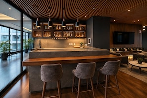 A modern kitchen with a bar area, bar stools, and a seating area with sofas and a coffee table. - Polanco Condo: Heated Pool, Jacuzzi, Near Antara (Mexico City)