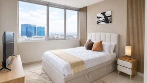 A modern bedroom with a large bed, bedside tables, a television, and a city view. - Executive apartment Vistas del Bosque near Polanco (Mexico City)