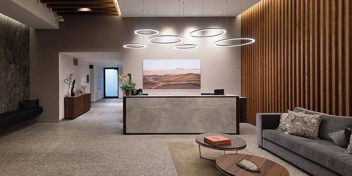 En moderne receptionsområde med receptionsdisk, sofa og sofabord.