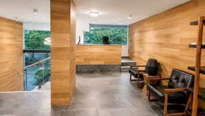 Un intérieur moderne avec un mur en bois, un comptoir d’accueil et un espace salon.
