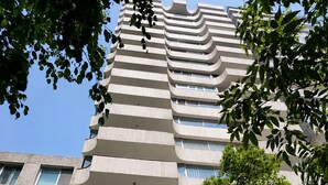 Un immeuble à plusieurs étages doté d’une architecture originale, avec des balcons et une porte de garage.