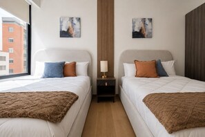 A hotel room with two beds, a nightstand with a lamp, and artwork on the walls. - Polanco Condo: Heated Pool, Gym & Antara Access (Mexico City)