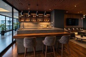 A modern kitchen with a bar area, bar stools, and a seating area with sofas and a coffee table. - Polanco Condo: Heated Pool, Gym & Antara Access (Mexico City)