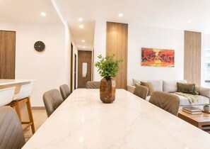 Ein modernes Wohnzimmer mit einem Marmortisch, einer Couch und einem Essbereich mit Stühlen.