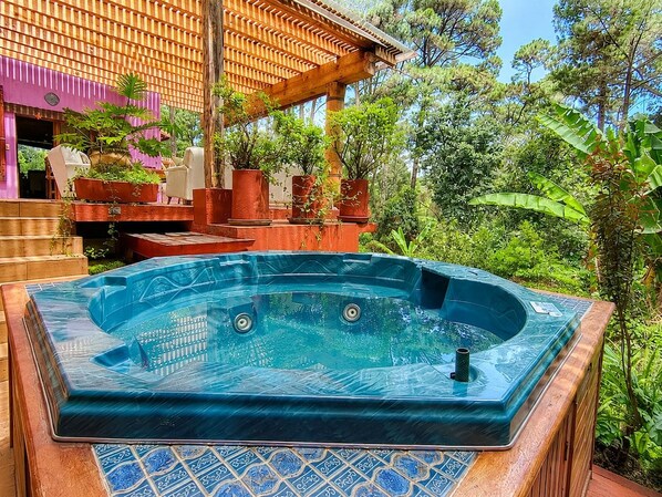 A hot tub with a wooden deck and a view of a wooden pergola and lush greenery. - Boutique River House w/ Jacuzzi & Gardens (Valle de Bravo)