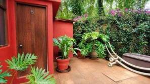 A red door, potted plants, and a garden with various foliage. - Boutique River House w/ Jacuzzi & Gardens (Valle de Bravo)