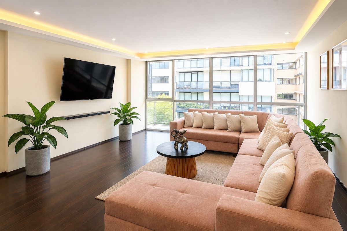 A modern living room with a sofa, a coffee table, and potted plants.