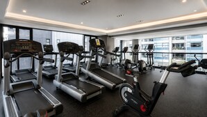 A gym with treadmills, elliptical machines, and a stationary bike. - Polanco 20th-Floor Condo: Pool, Gym, City Views (Mexico City)