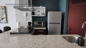 A kitchen with a granite countertop, stainless steel appliances, a microwave, and a refrigerator. - Polanco 20th-Floor Condo: Pool, Gym, City Views (Mexico City)