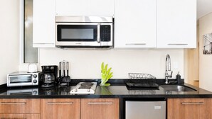 A modern kitchen with a microwave, toaster, coffee maker, and a sink. - Condesa Loft w/ Pool, Sauna & Private Parking (Mexico City)