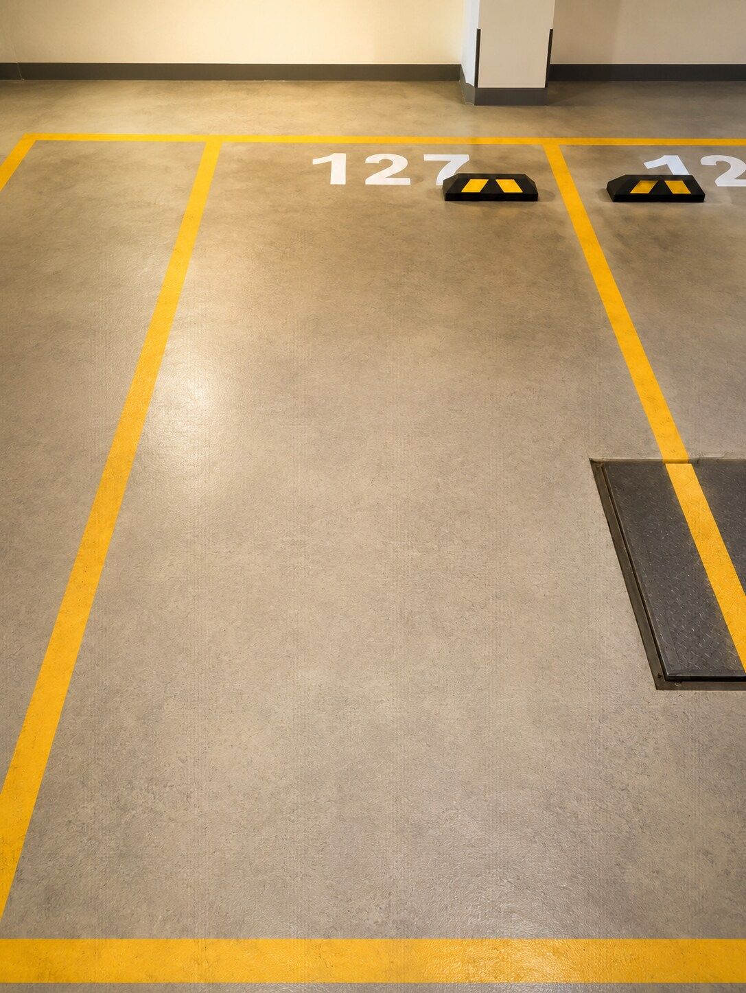 Ein Parkplatz mit gelben Linien und nummerierten Stellplätzen.