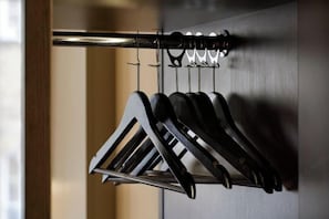 A wall-mounted rack with multiple black hangers. - London Holborn (London)