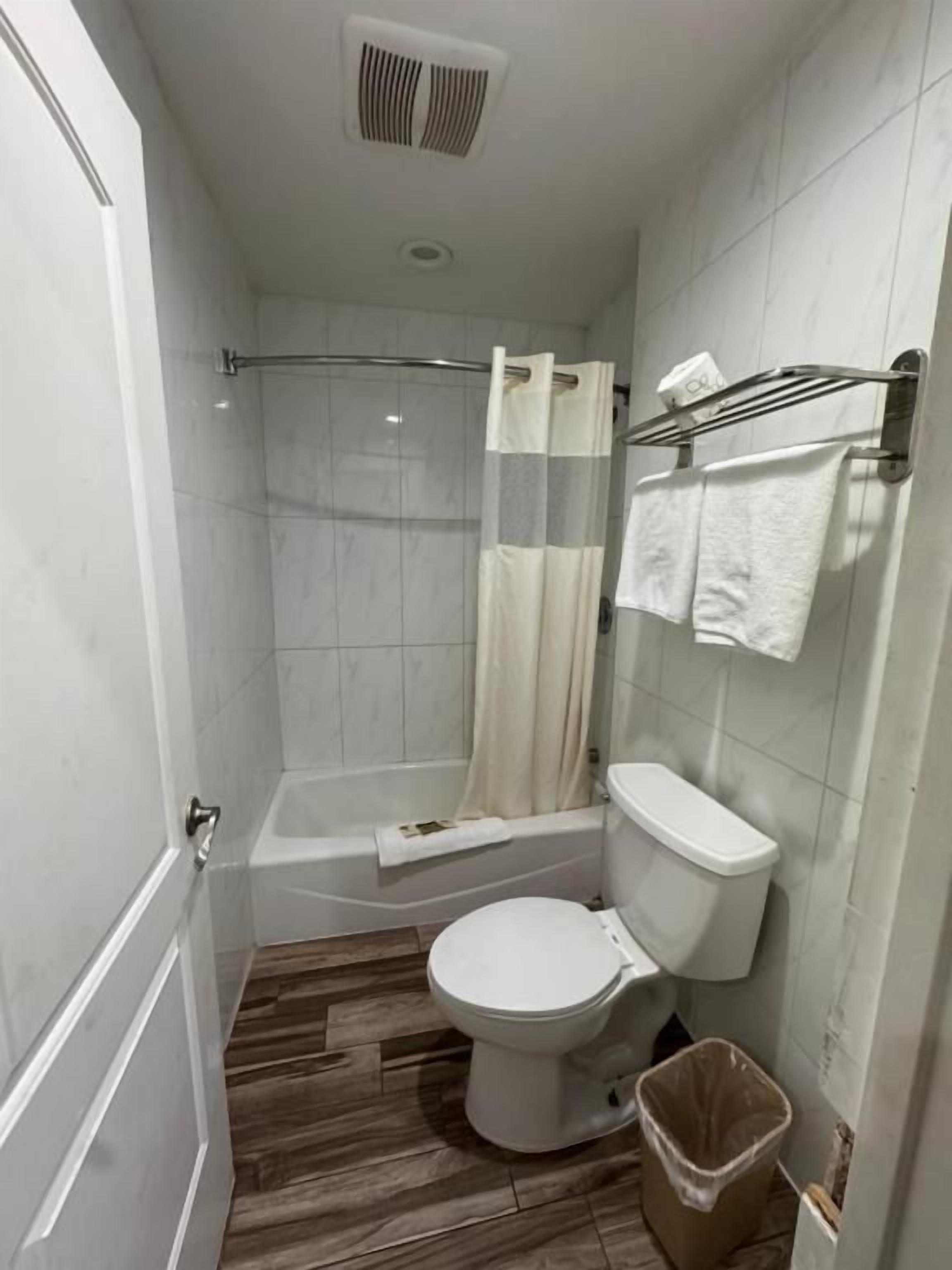 A bathroom with a toilet, shower, and bathtub.