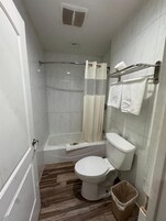 Un baño con inodoro, ducha y bañera.
