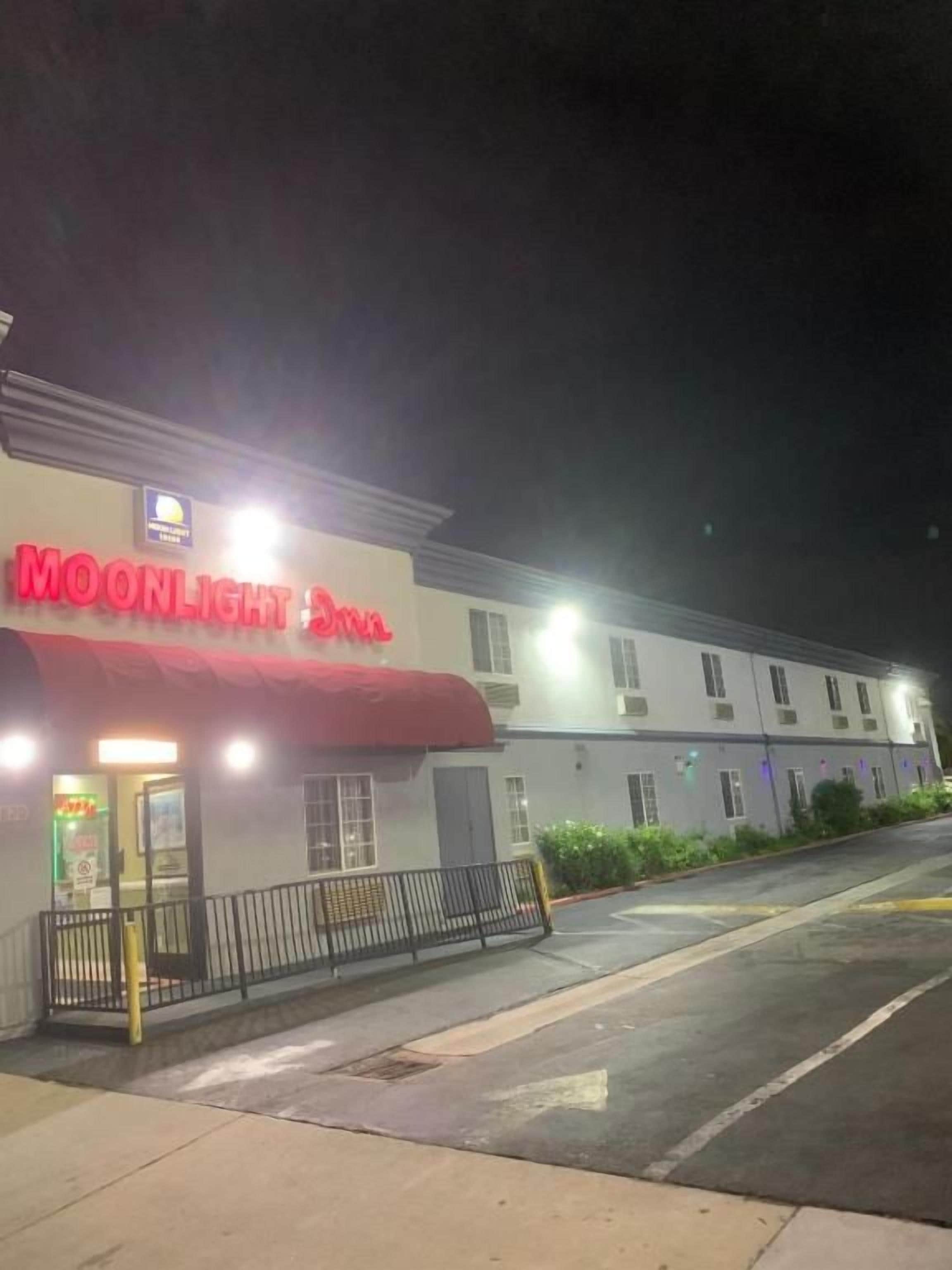 Un edificio con toldo rojo y un letrero que dice 'MOONLIGHT Inn'.