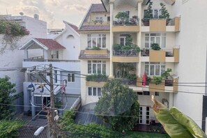 A multi-story residential building with balconies, a visible staircase, and a garden area. - Zeus Living - Cozy Apartment in Thao Dien (Ho Chi Minh City)