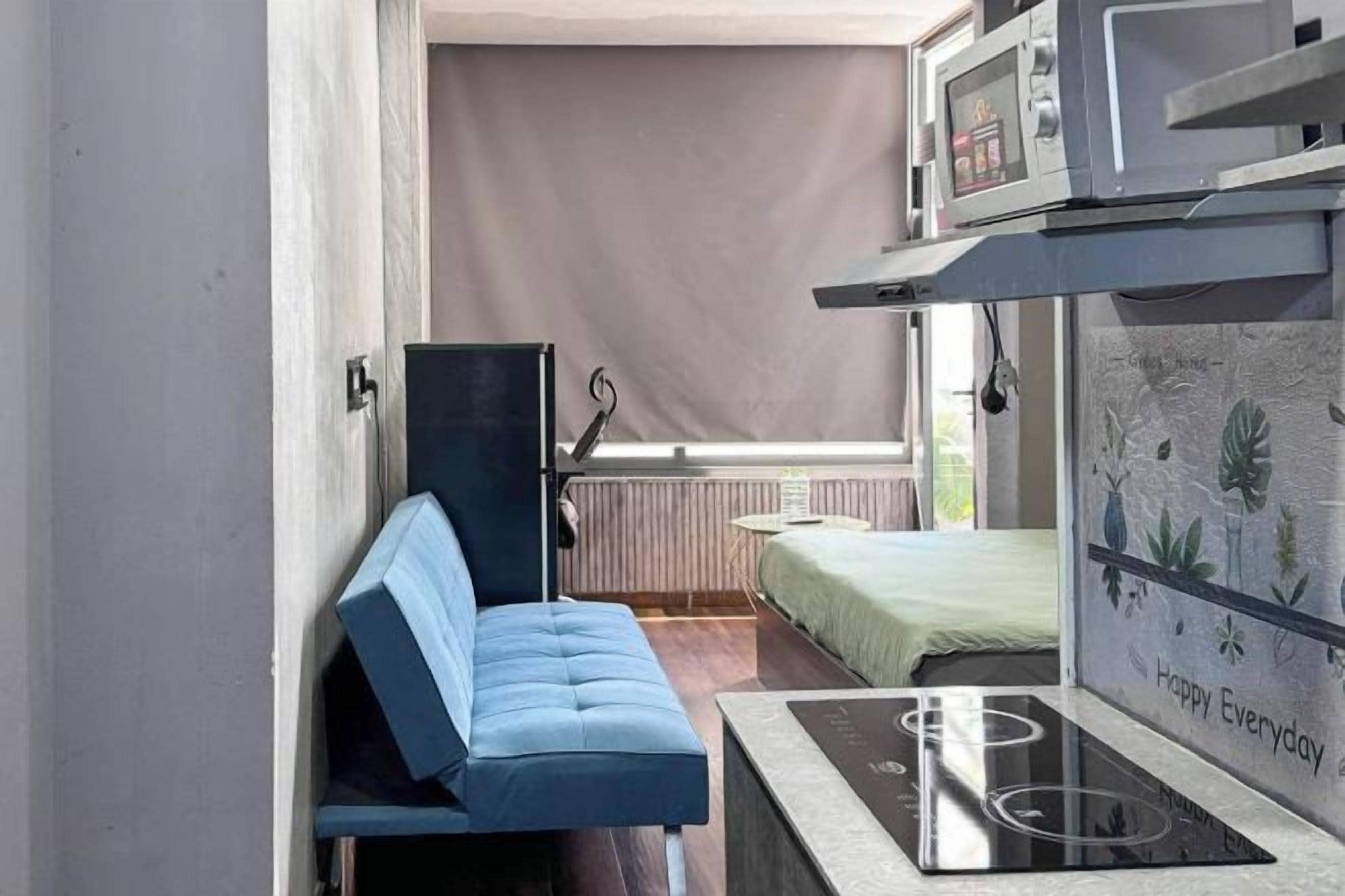 Ein kleines Zimmer mit einem Bett, einem Tisch und einer Sitzbank.
