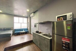 A compact kitchen with a stainless steel refrigerator, a built-in oven, and a sink. - Zeus Living - Cozy Apartment in Thao Dien (Ho Chi Minh City)