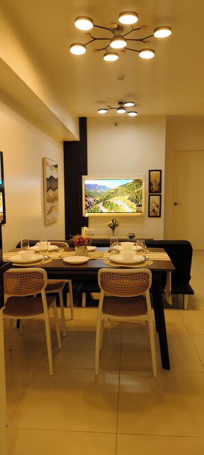 Un comedor con una mesa dispuesta para cuatro personas, un ventanal con vistas panorámicas y una lámpara de techo moderna.
