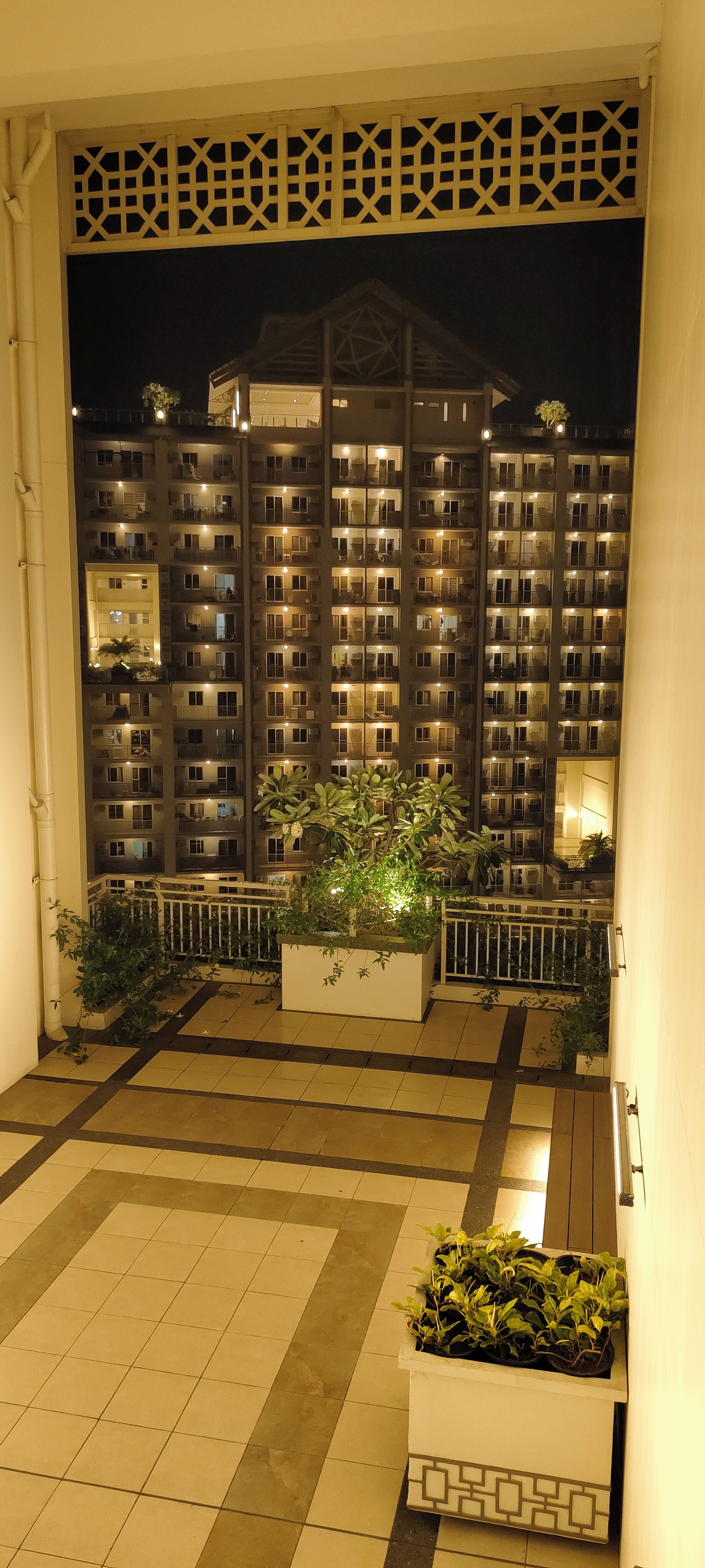 A multi-story hotel building at night with illuminated windows and balconies.