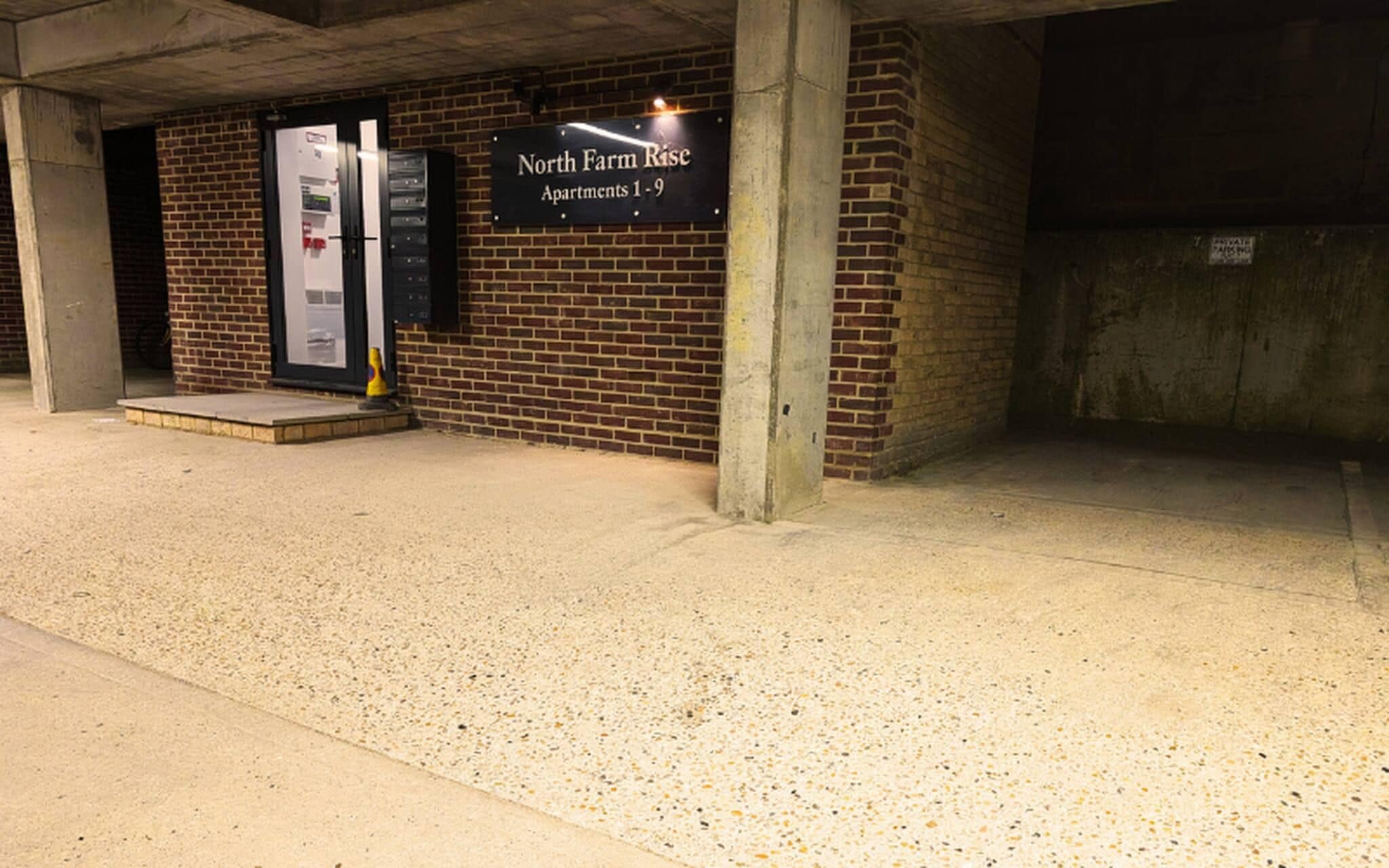 A parking garage entrance with a sign for 'North Farm Rise Apartments 1-9'.