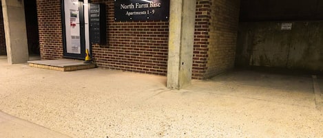 A parking garage entrance with a sign for 'North Farm Rise Apartments 1-9'.