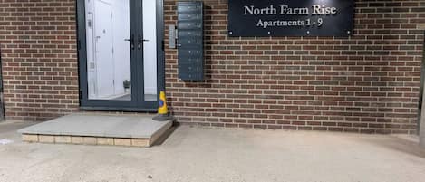 A building entrance with a sign for North Farm Rise Apartments 1-9.