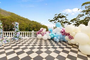 A checkered outdoor area with a white balustrade, surrounded by trees and a clear sky. - Luxury Waterfront Retreat with Private Pool (Daleys Point)