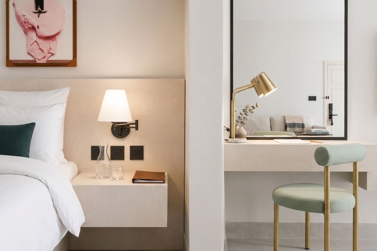 Une chambre d’hôtel avec un lit, une table de chevet, une lampe et une chaise.