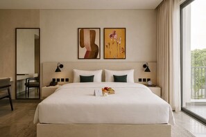 A hotel room with a large bed, two bedside tables with lamps, a desk, and a chair. There are two framed artworks on the wall above the bed. - Wonderful 1-bedroom hotel suites with AC in Islamabad Capital Territory (Islamabad Capital Territory)
