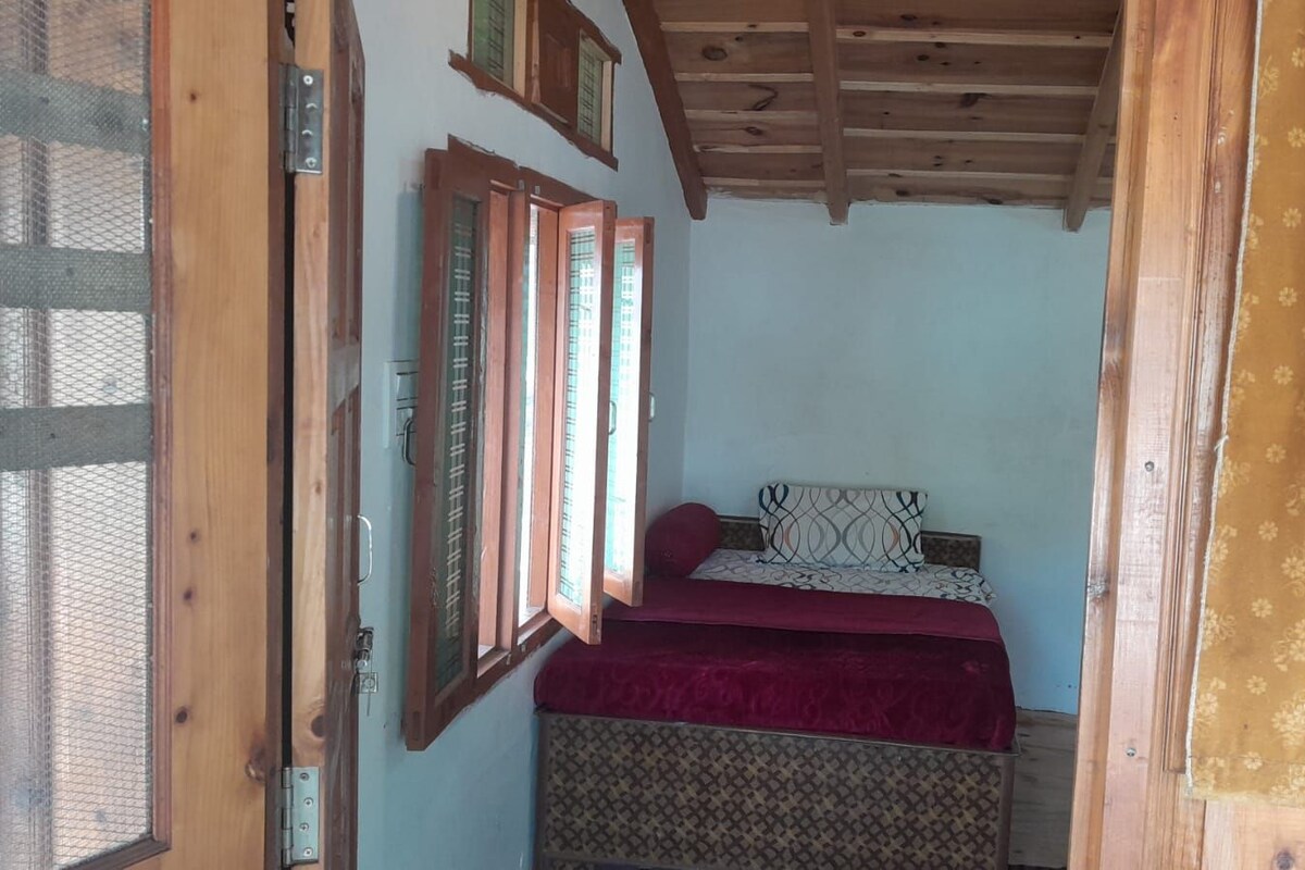 A room with a bed, a window, and a door.