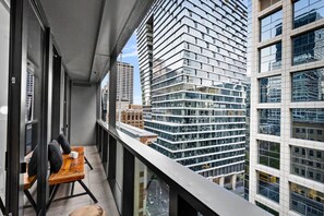 Ein Balkon mit Tisch, Stühlen und Blick auf hohe Gebäude.