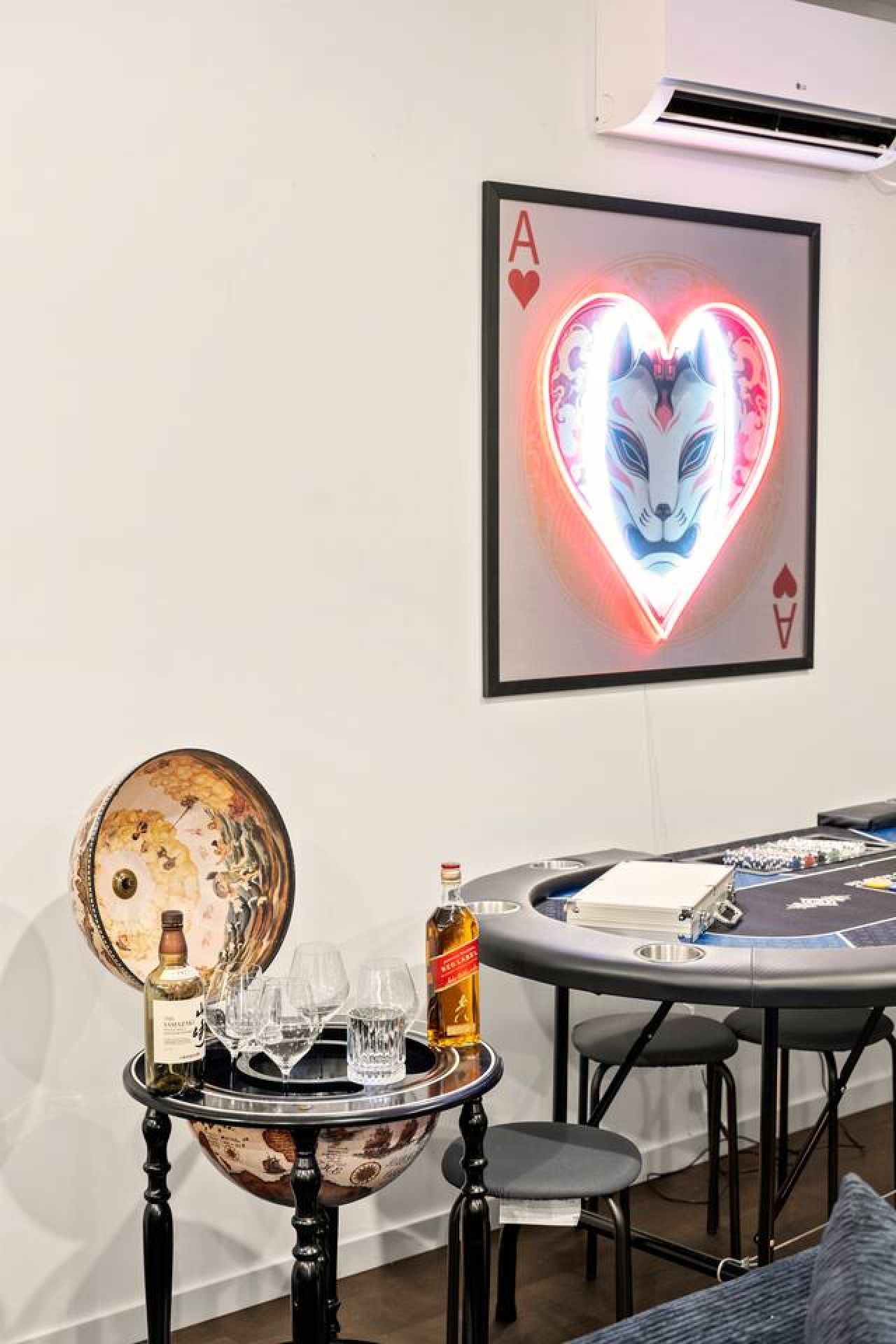 A room with a table set for a meal, a framed picture on the wall, and a decorative mirror.