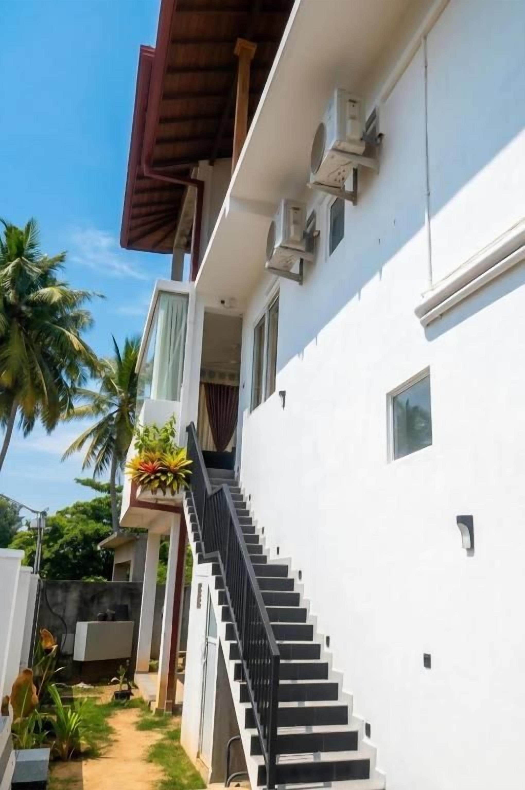 Un bâtiment blanc avec un escalier menant à un balcon.