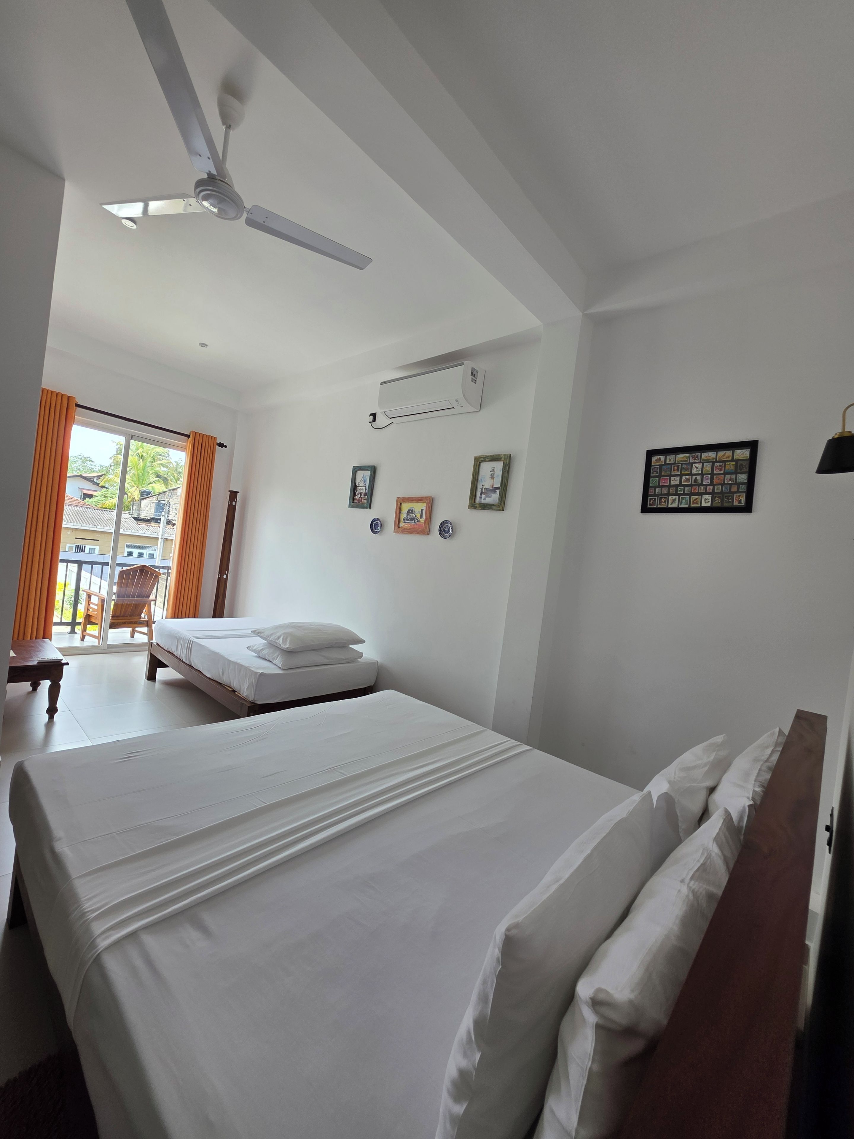 Une chambre d’hôtel équipée d’un lit, d’un ventilateur de plafond, d’un appareil de climatisation et offrant une vue sur l’extérieur.