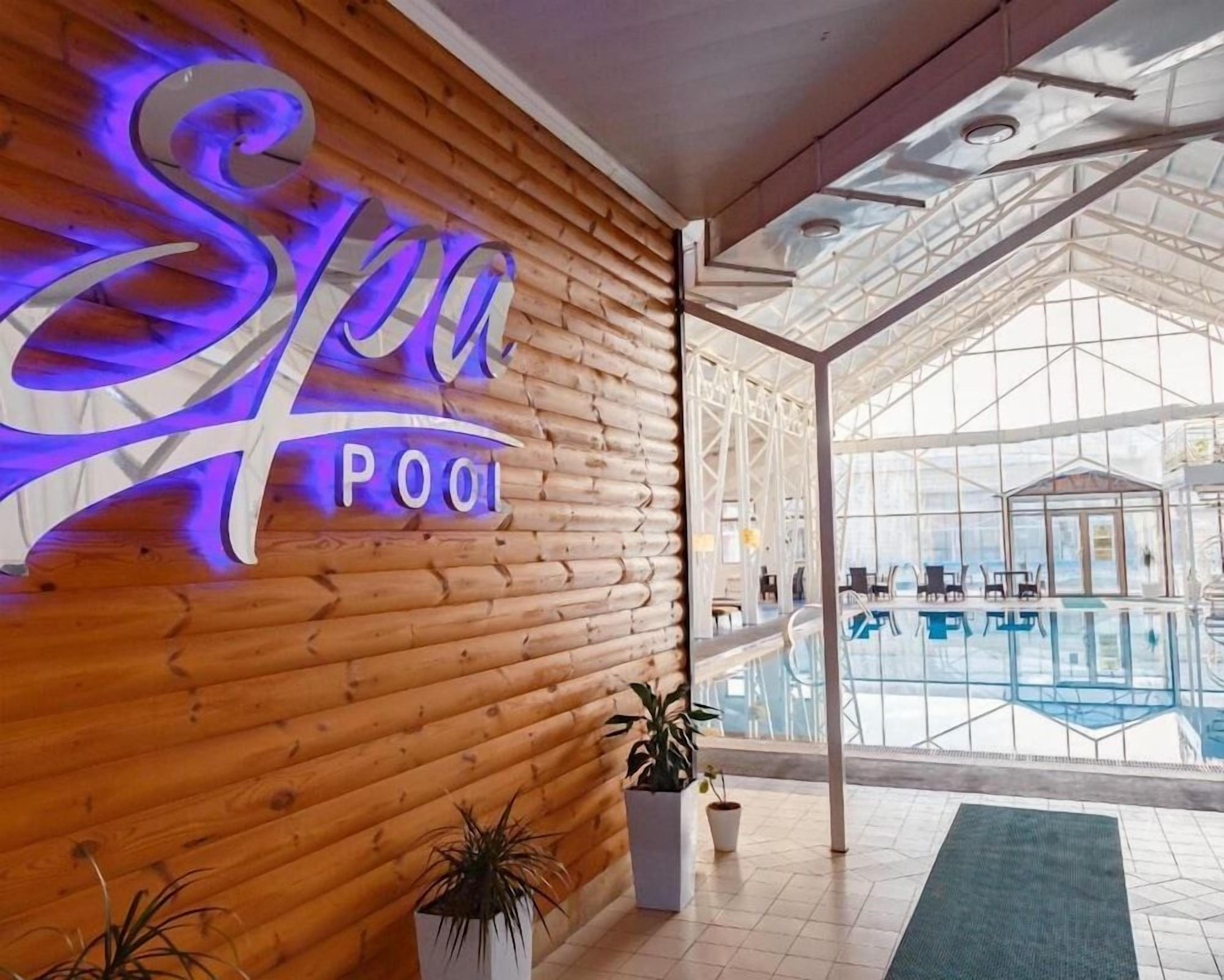 Zona de piscina termal con pared de madera y un letrero que dice 'Spa Pool'.
