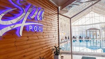 Zona de piscina termal con pared de madera y un letrero que dice 'Spa Pool'.