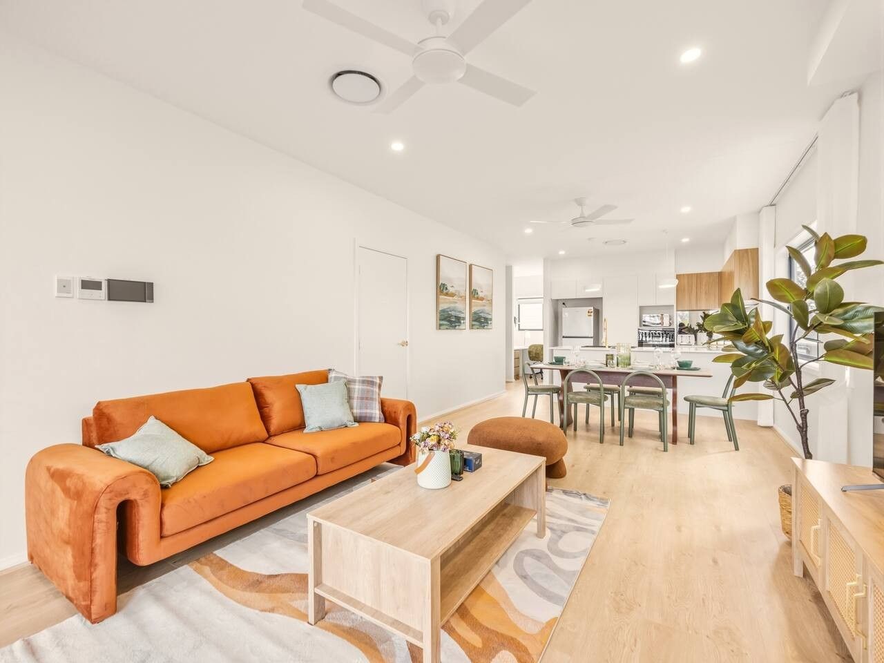 A modern living room with a sofa, coffee table, and dining area.