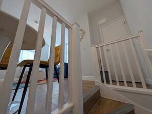 A staircase with white railings leading to an upper floor.