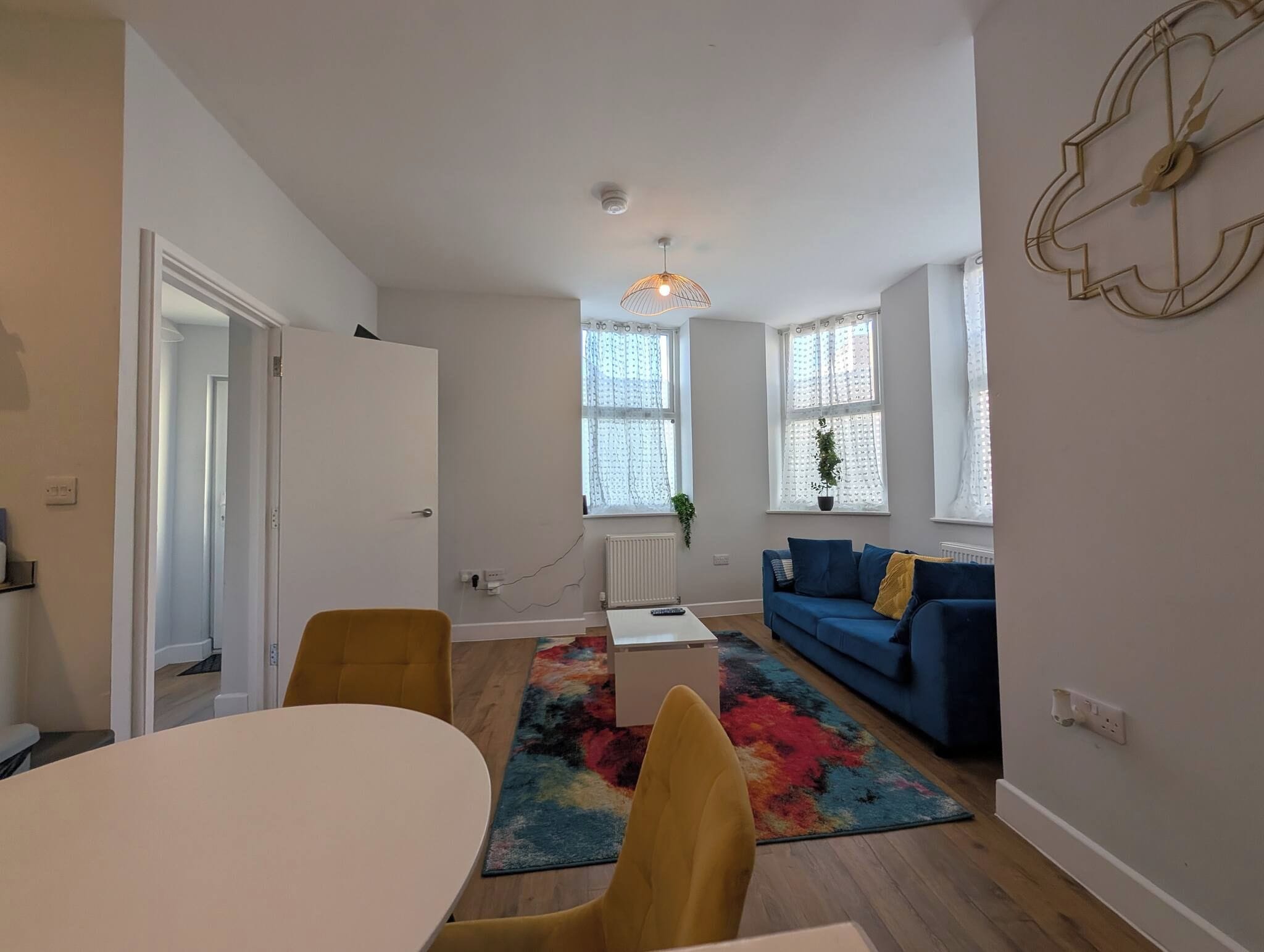 A modern living room with a sofa, a coffee table, and a dining table.