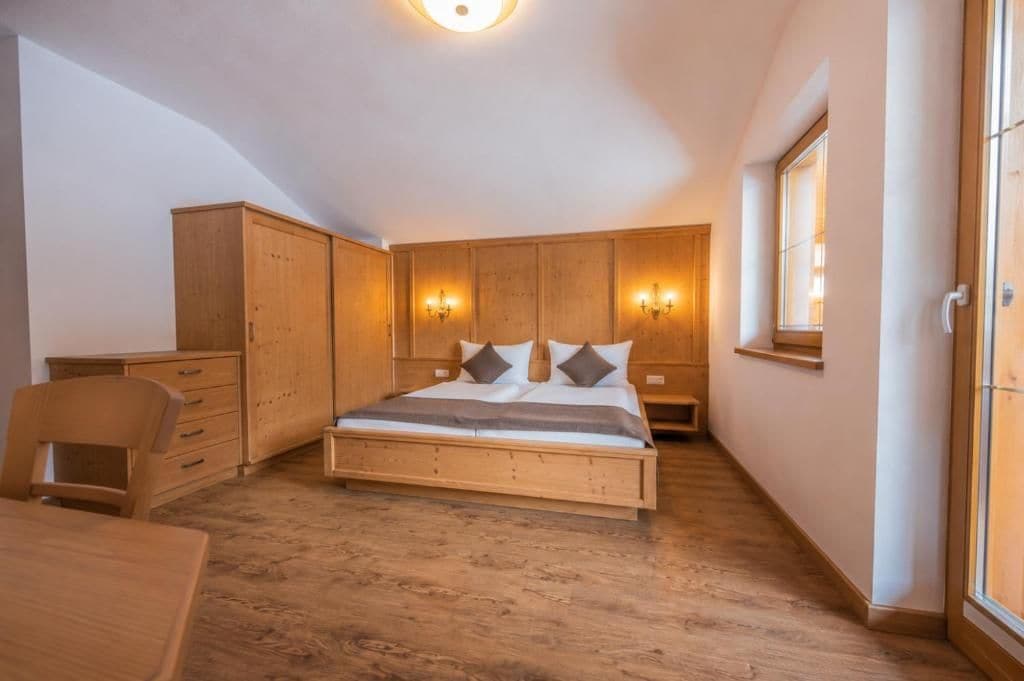 Une chambre à coucher avec un lit en bois, un bureau et une chaise.