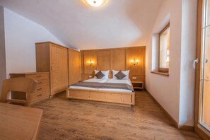 Un dormitorio con una cama de madera, un escritorio y una silla.