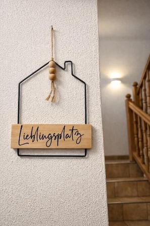 A wall-mounted sign with a house outline and a tassel, and a wooden plaque with text. - Alpenchalet Vital (Neustift im Stubaital)