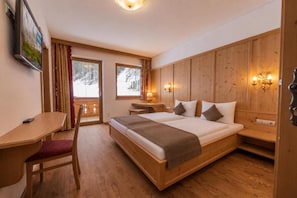 Una habitación con estructura de madera, una cama, un escritorio y una silla.