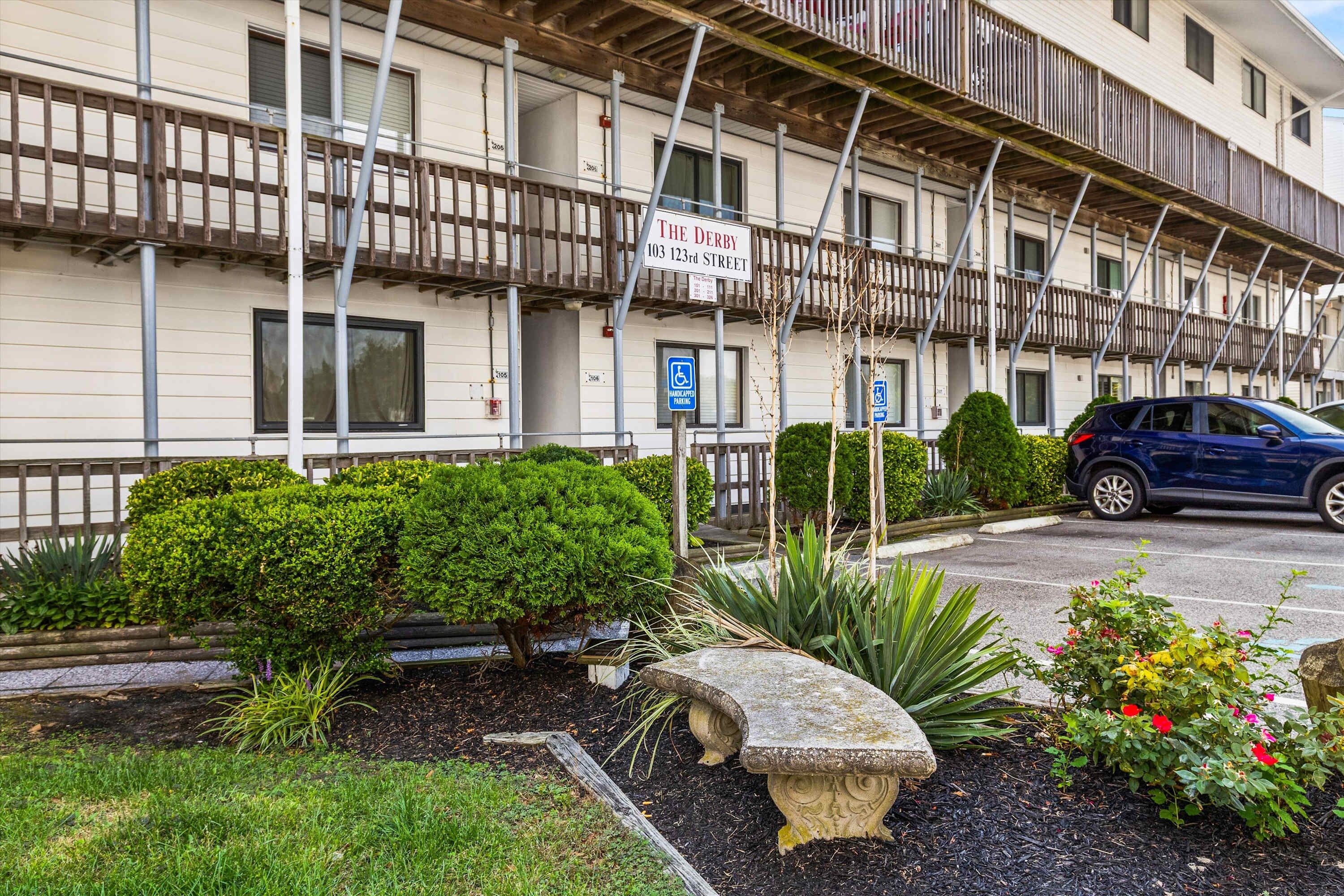A multi-story building with a sign indicating 'The Derby 103 123rd Street.'